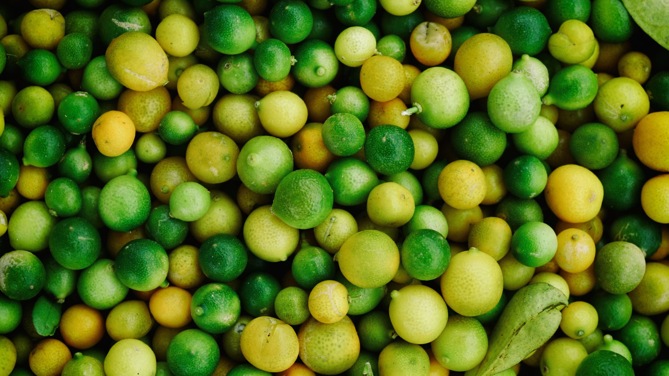 pile of hundreds of green and yellow fruits